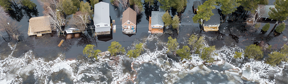 Aerial view of flooded cottages in Grand Lake, New Brunswick. Large ice chunks approach, propelled by wind and flood waters.