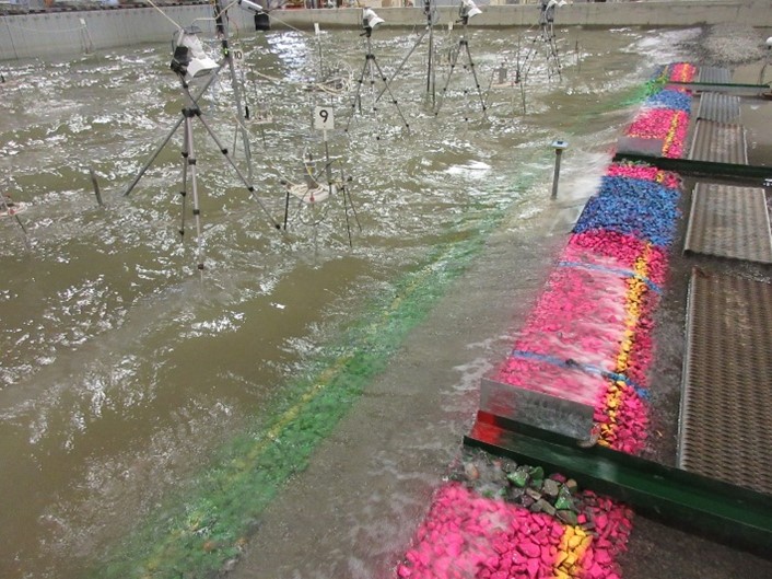 Photograph of measurement tools in a scaled physical model of a coastal region in a research laboratory.
