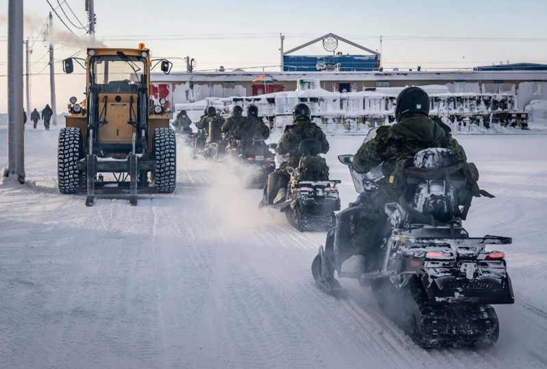A group of people riding motorcycles in the snow