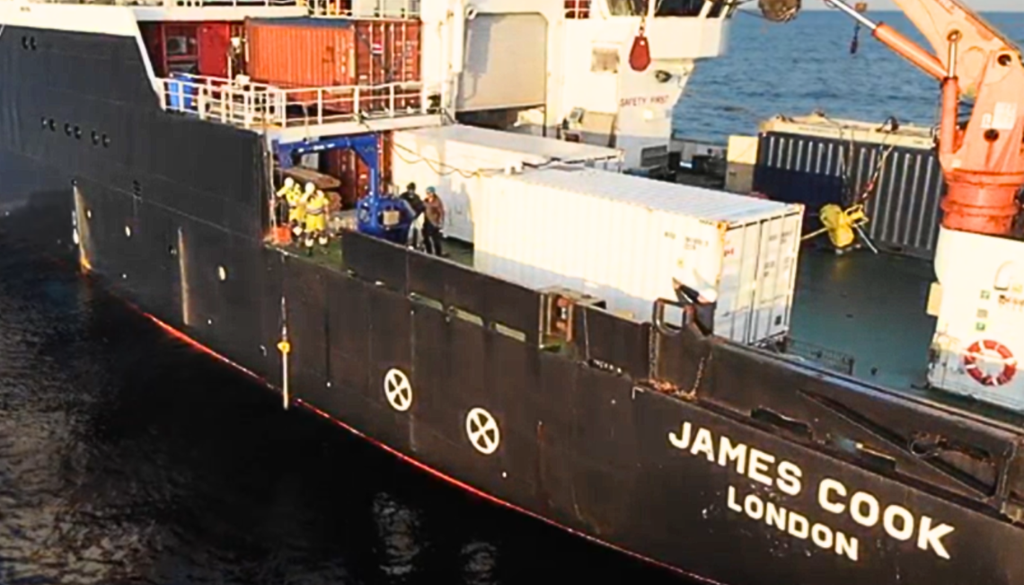 The side of a large sea vessel with the name James Cook, London, painted on the side.