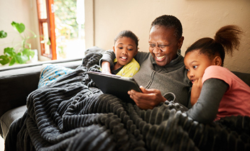 Grandmother and granddaughters watching content on a tablet. 