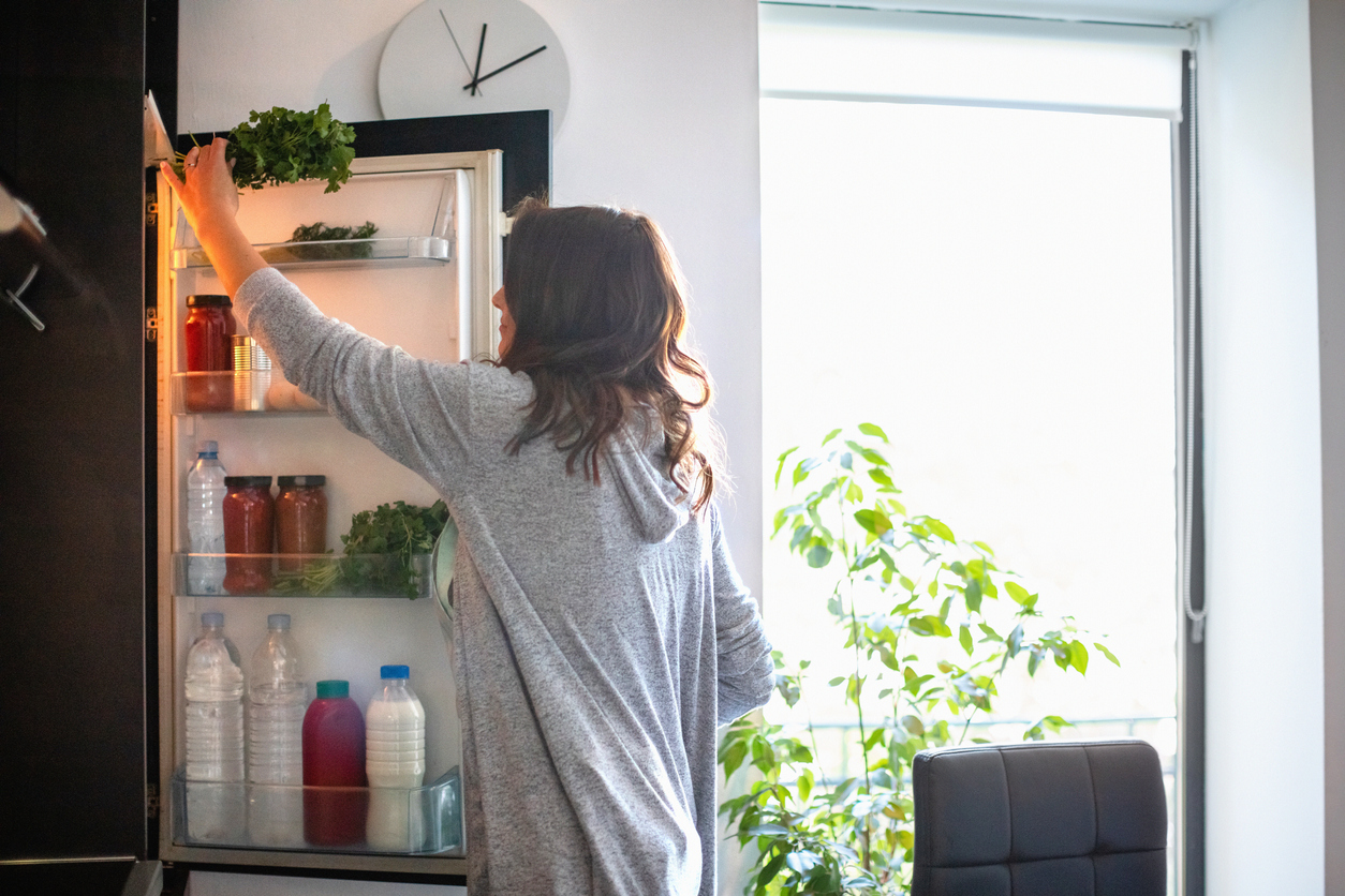 Woman opens fridge.