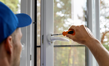 Serviceman installing window.