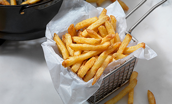 Crispy French fries in steel basket