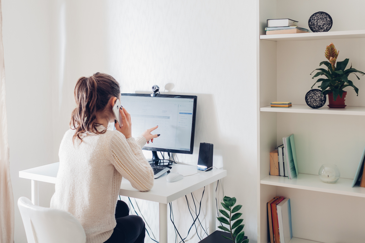 Woman talking on the phone while working from home.