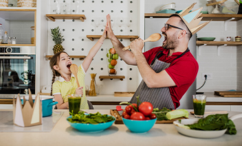 Father and daughter singing in the kitchen