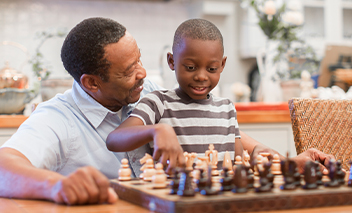 Grandfather plays chess with his grandson.