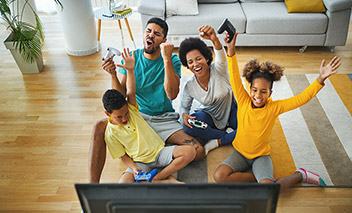 Family sitting together on the floor playing video games