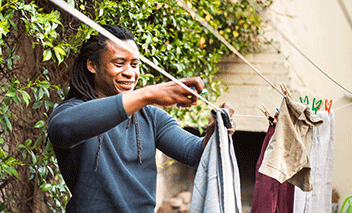 A man haning clothes on a clothesline