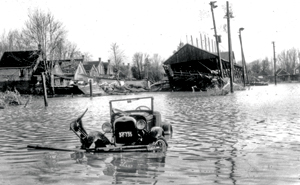 Archival photograph of old submerged car on flooded street in London Ontario