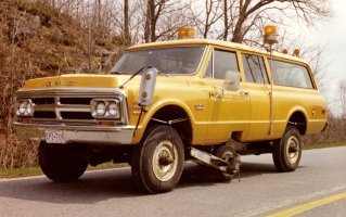 Yellow truck on the road equipped with custom levelling instruments attached
