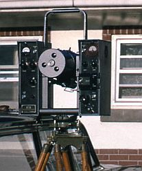 EDM setup on a tripod with a brick building in the background