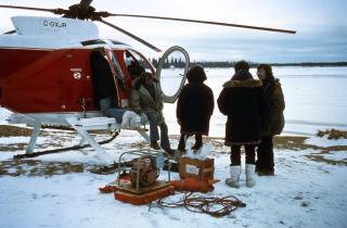 Airplane on the ground with technician and equipment with snow in the background