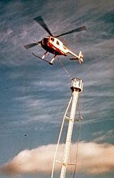 Helicopter erecting a tower with a sky background