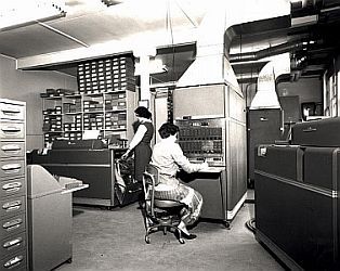 Two technicians work at a large computer