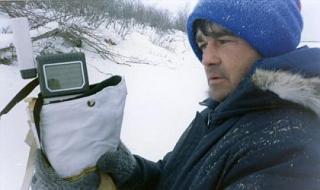 Technician holding a handheld GPS outside in the wintertime