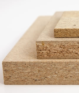 Three pieces of particle board laying flat with thickest piece on the bottom