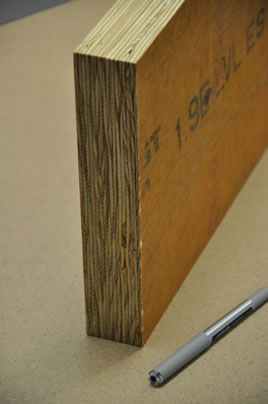 A laminated veneer lumber panel standing on its edge with a pen next to it for scale.