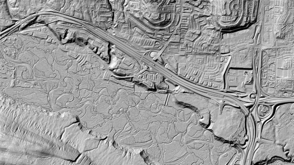 Black and white 3D reliefs of the surface of the ground including roads, water and terrain.