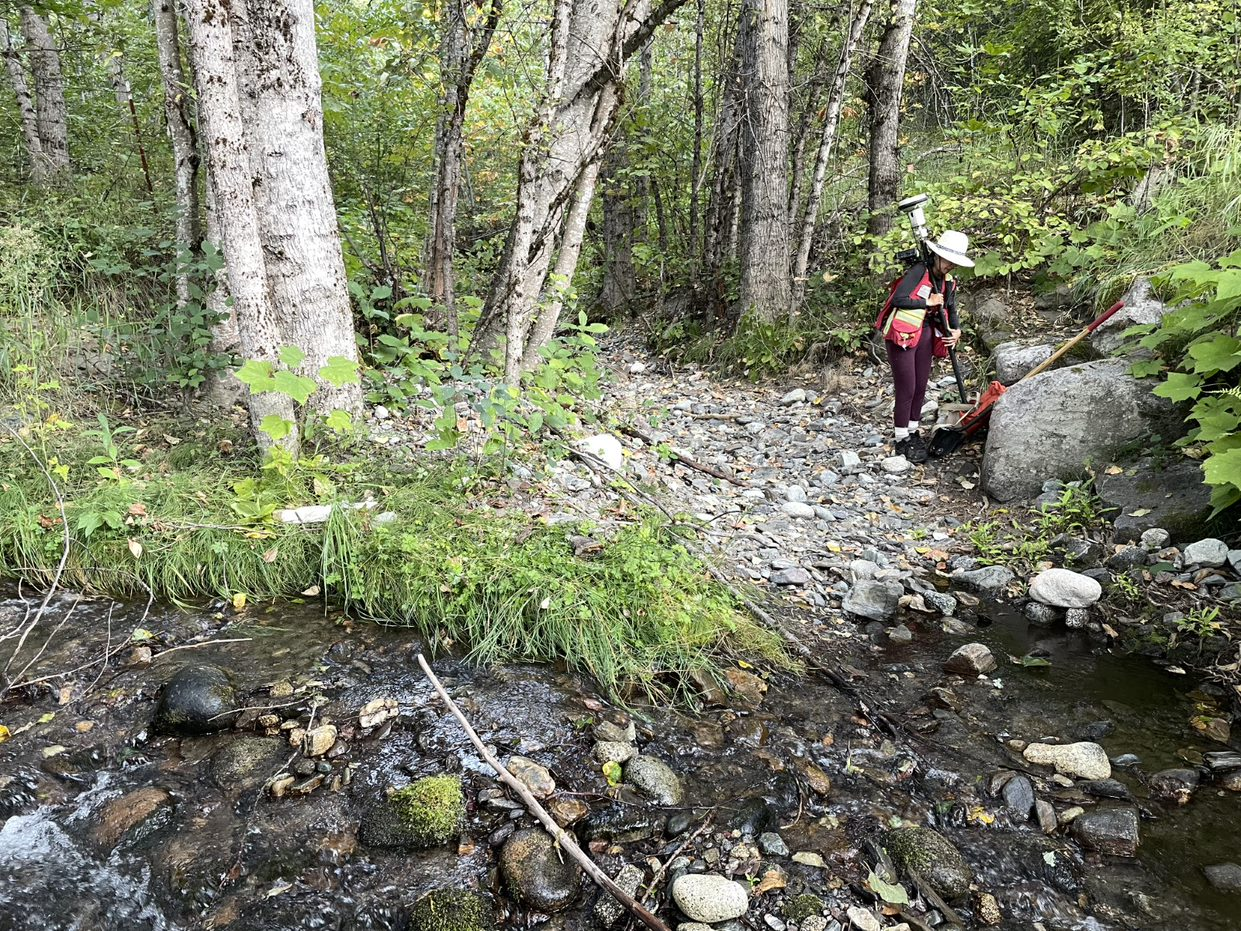 Person standing on a rocky path in Kopchitchin investigating natural boundary