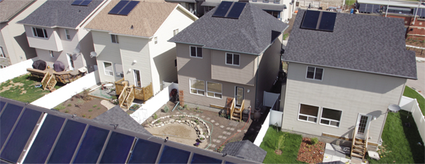 aerial photo of residential houses with solar panels on their roofs.