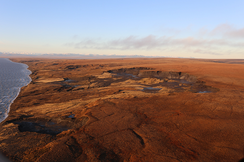 Photo of Arctic coastline with large sinkhole.