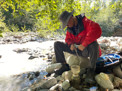 Researcher collects data from a stream on Mount Cayley.