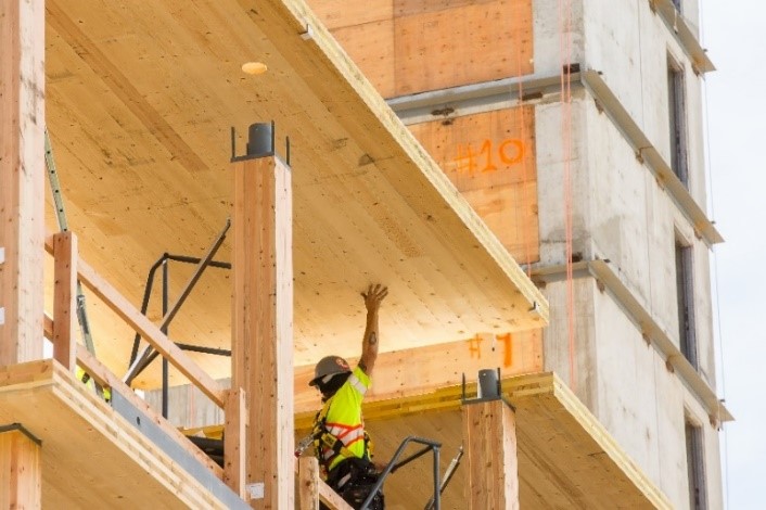 A construction worker helps to assemble engineered mass timber on upper floors of Brock Commons Tallwood House.